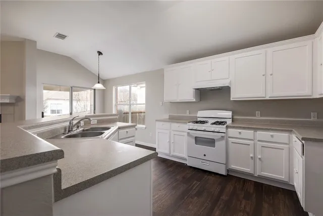 a kitchen with a sink a stove and cabinets