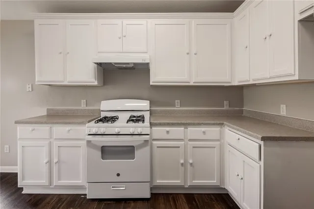 a kitchen with white cabinets and white appliances