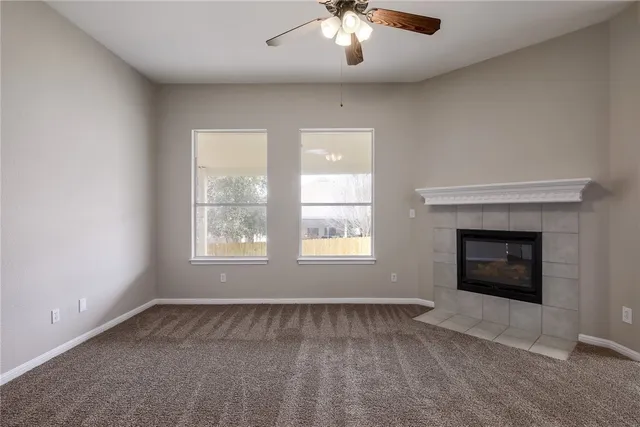 an empty room with a fireplace and windows