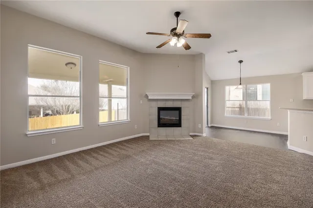 an empty room with windows and fireplace