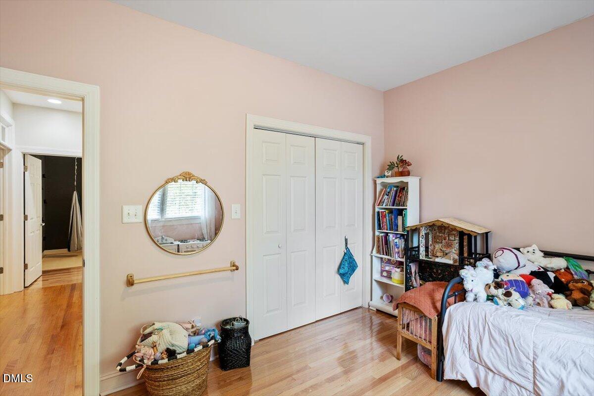 321 Efland - Cedar Grove Road Efland, NC 27243 - Photo 26 of 45 a bedroom with a bed wooden floor and a mirror