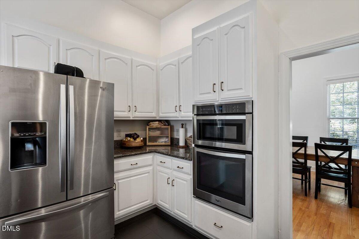 321 Efland - Cedar Grove Road Efland, NC 27243 - Photo 6 of 45 a kitchen with stainless steel appliances white cabinets and wooden floors