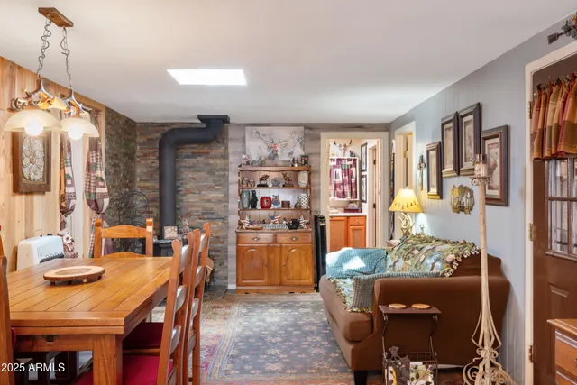 a living room with stainless steel appliances furniture a rug and a kitchen view