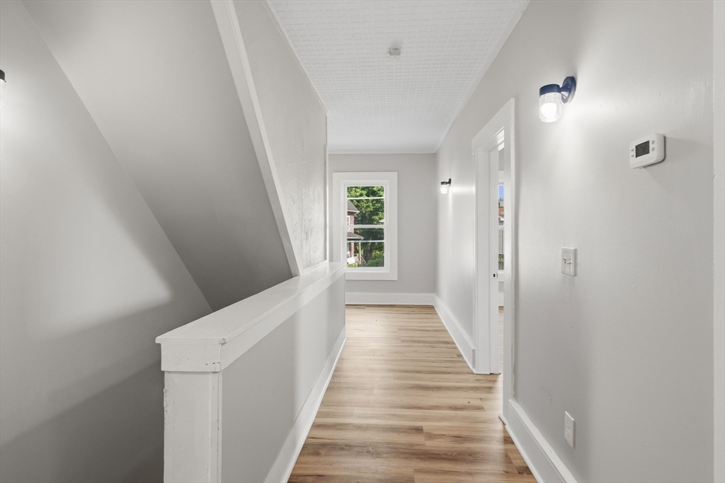 834 Worthington Street, Unit 2 Springfield, MA 01105 - Photo 4 of 20 a view of a hallway with wooden floor and staircase