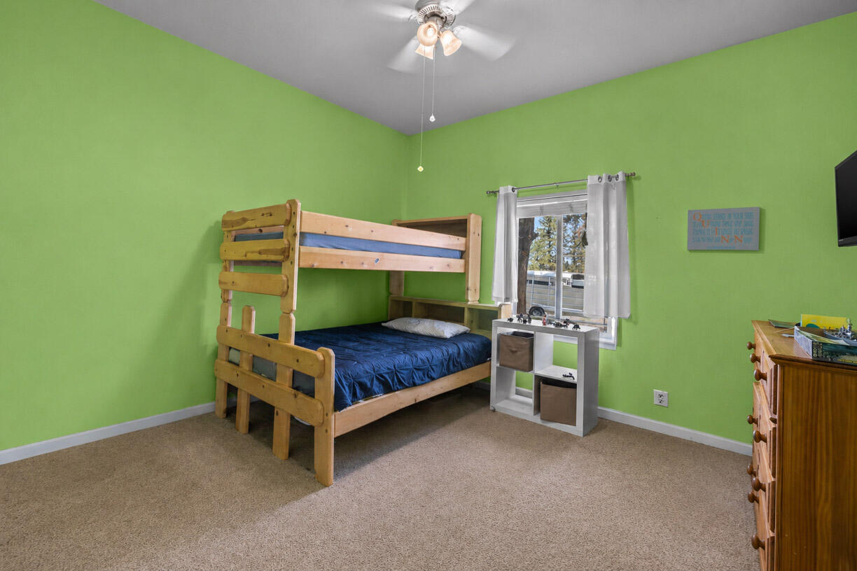 67500 Harrington Loop Road Bend, OR 97703 - Photo 20 of 72 a bedroom with a bed and a chandelier