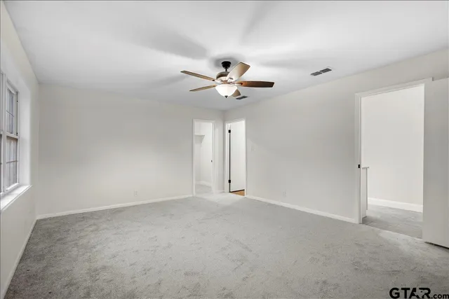 a bathroom with a granite countertop sink a toilet and a mirror