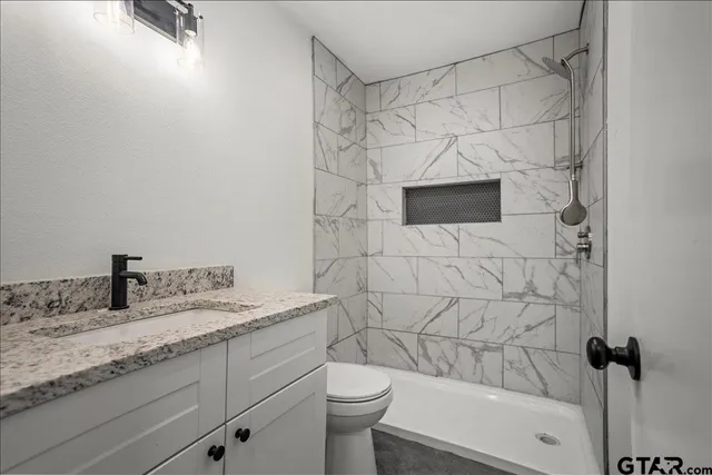 a view of an empty room with chandelier fan