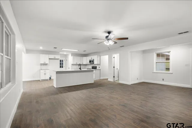 a large kitchen with cabinets wooden floor and a sink
