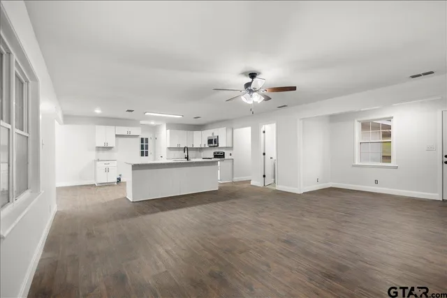 a large kitchen with stainless steel appliances granite countertop a stove oven and a refrigerator