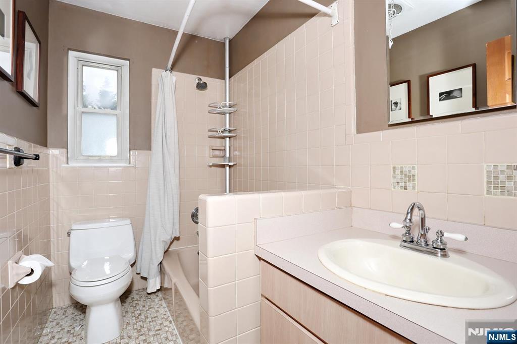 87 Barbara Road Dumont, NJ 07628 - Photo 26 of 48 a bathroom with a sink toilet vanity and shower