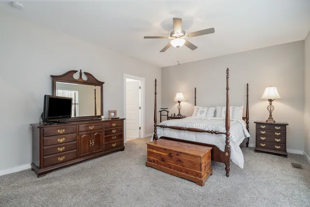 a spacious bedroom with a bed and a flat screen tv