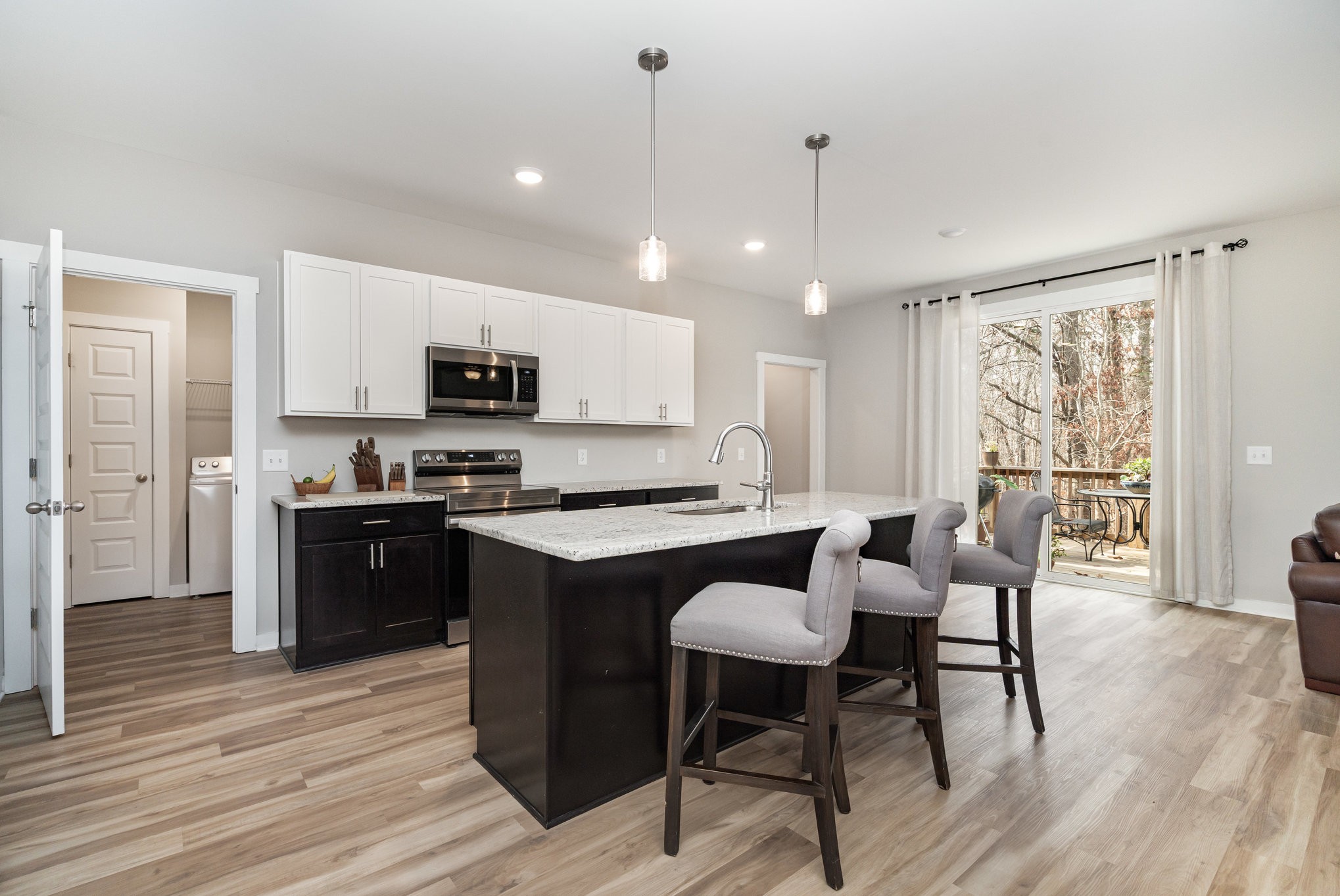2074 Morgan Court Springfield, TN 37172 - Photo 7 of 24 a open kitchen with stainless steel appliances granite countertop a stove a refrigerator a kitchen island a dining table and chairs with wooden floor