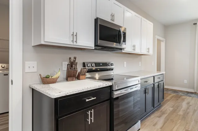 a kitchen with stainless steel appliances granite countertop a sink stove and microwave