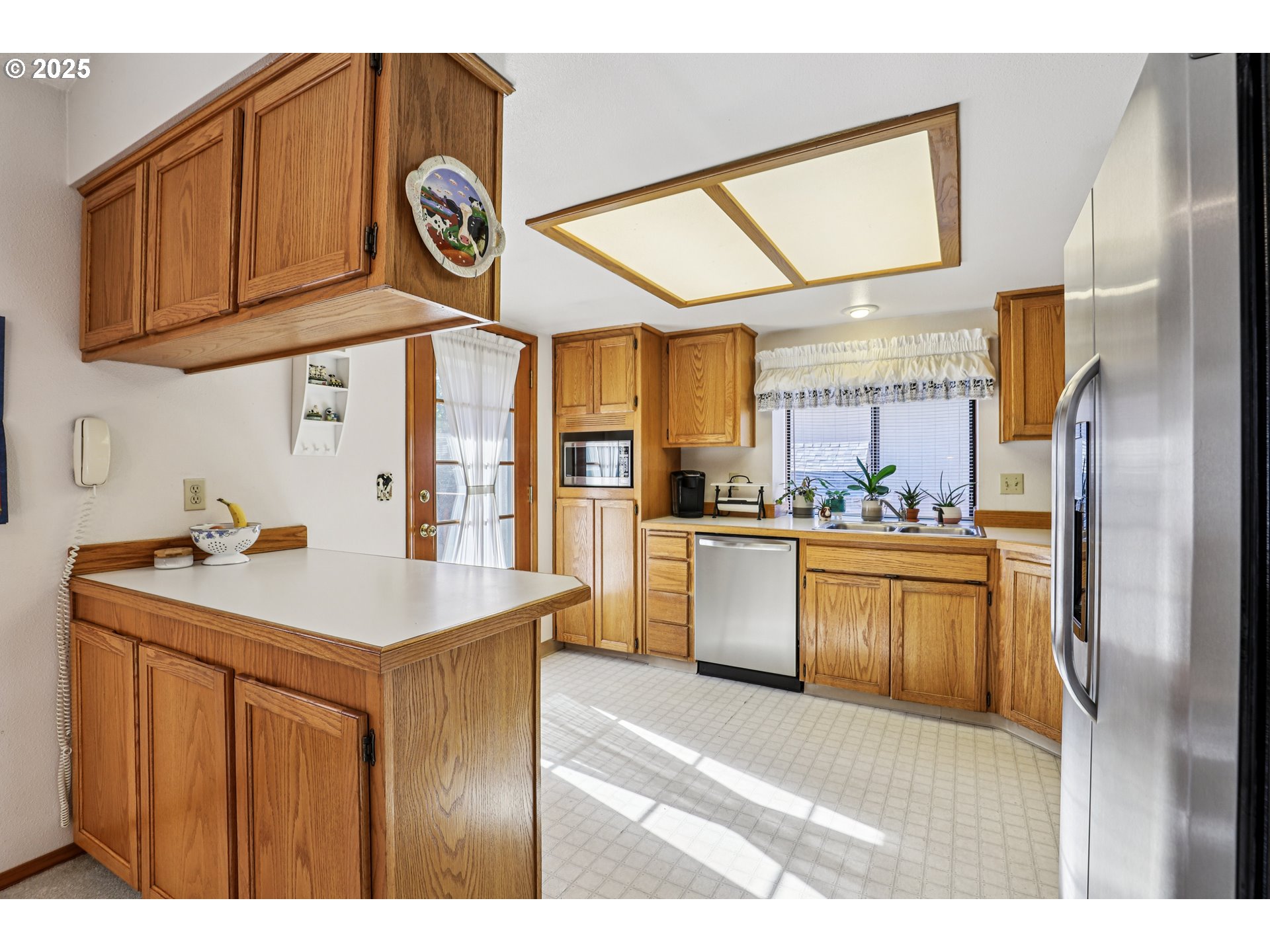 3786 Southwest 8th Street Gresham, OR 97030 - Photo 11 of 43 a kitchen with stainless steel appliances granite countertop a sink a refrigerator and a wooden cabinets