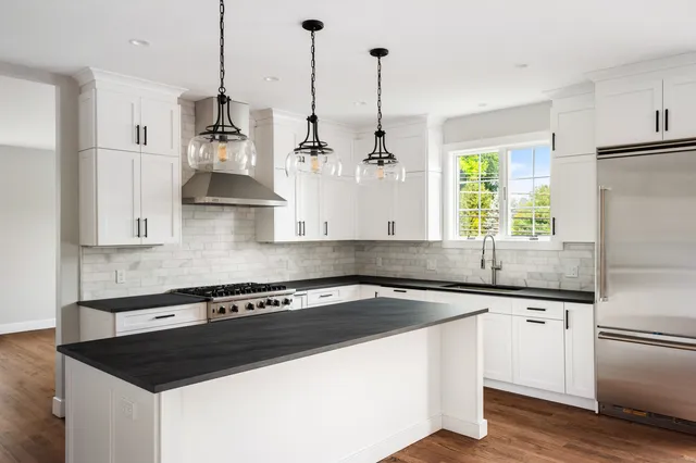 a kitchen with stainless steel appliances granite countertop a sink a stove and a refrigerator