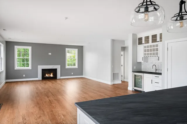 a view of a room with wooden floor fireplace and windows