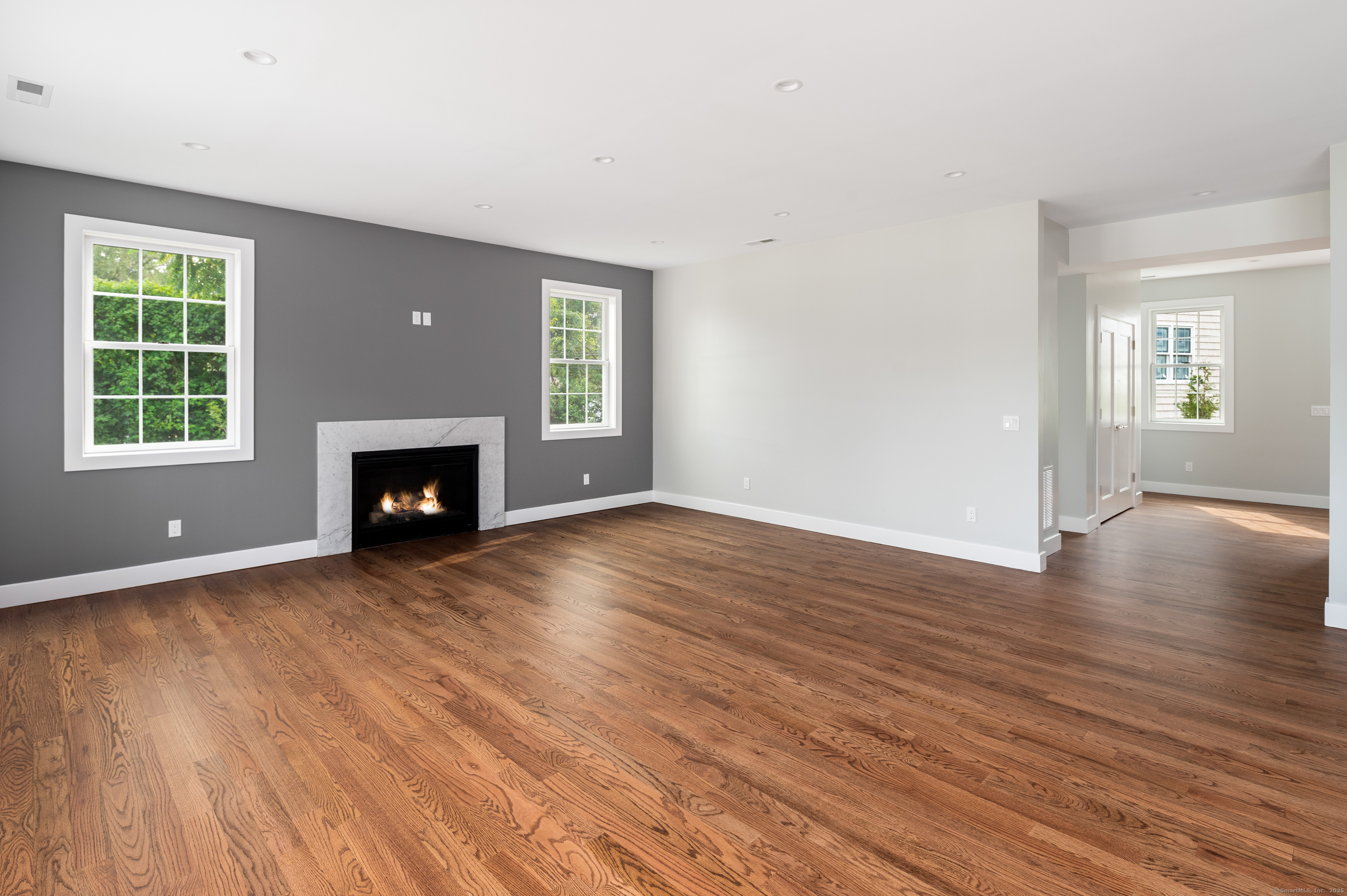6 Walnut Ridge Court Stamford, CT 06905 - Photo 19 of 35 an empty room with wooden floor a fireplace and windows