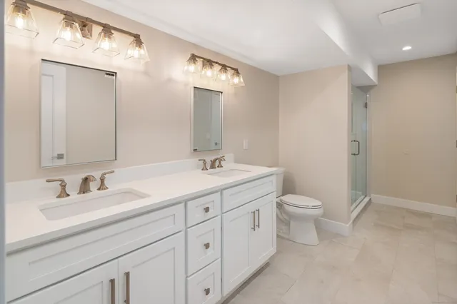 a bathroom with a toilet a sink and mirror