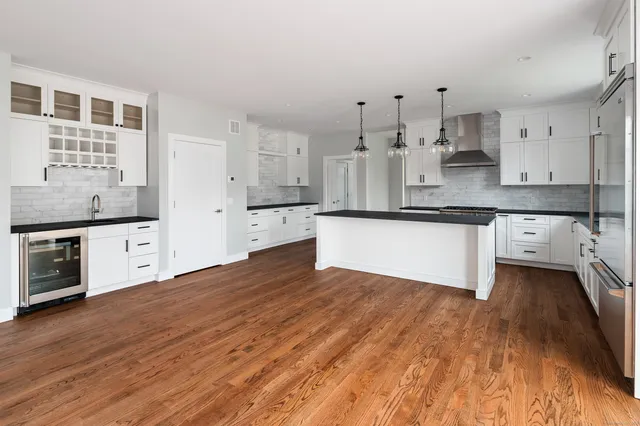 a large kitchen with cabinets and wooden floor