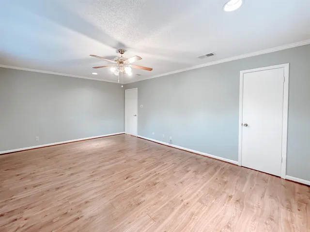a view of an empty room with wooden floor