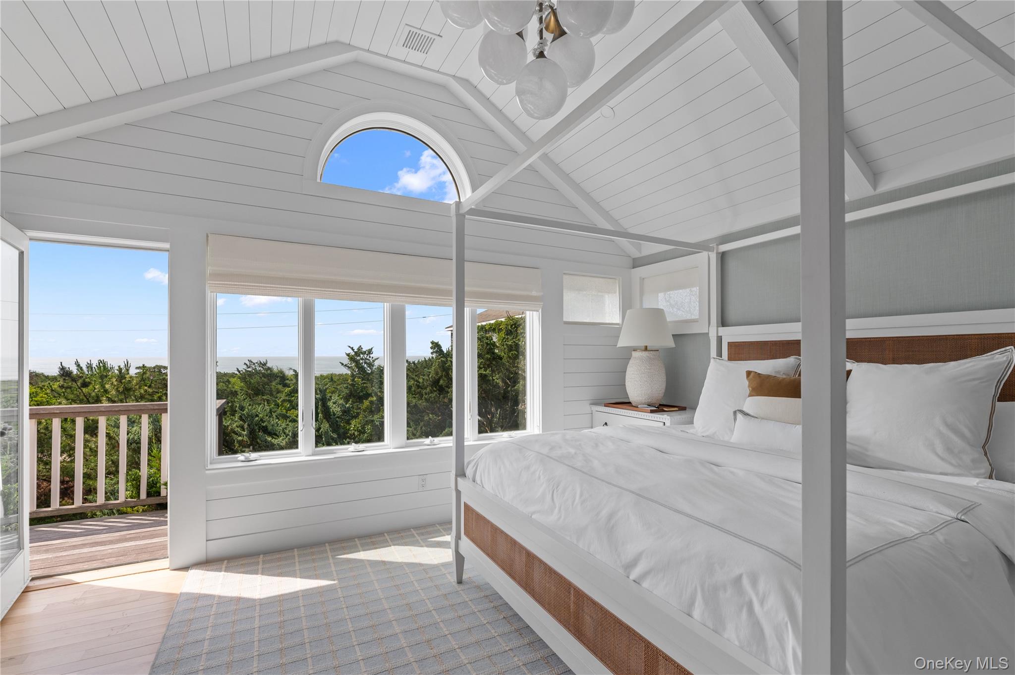1005 Surf View Ocean Beach, NY 11770 - Photo 19 of 43 a bedroom with a large bed and a large window with balcony view
