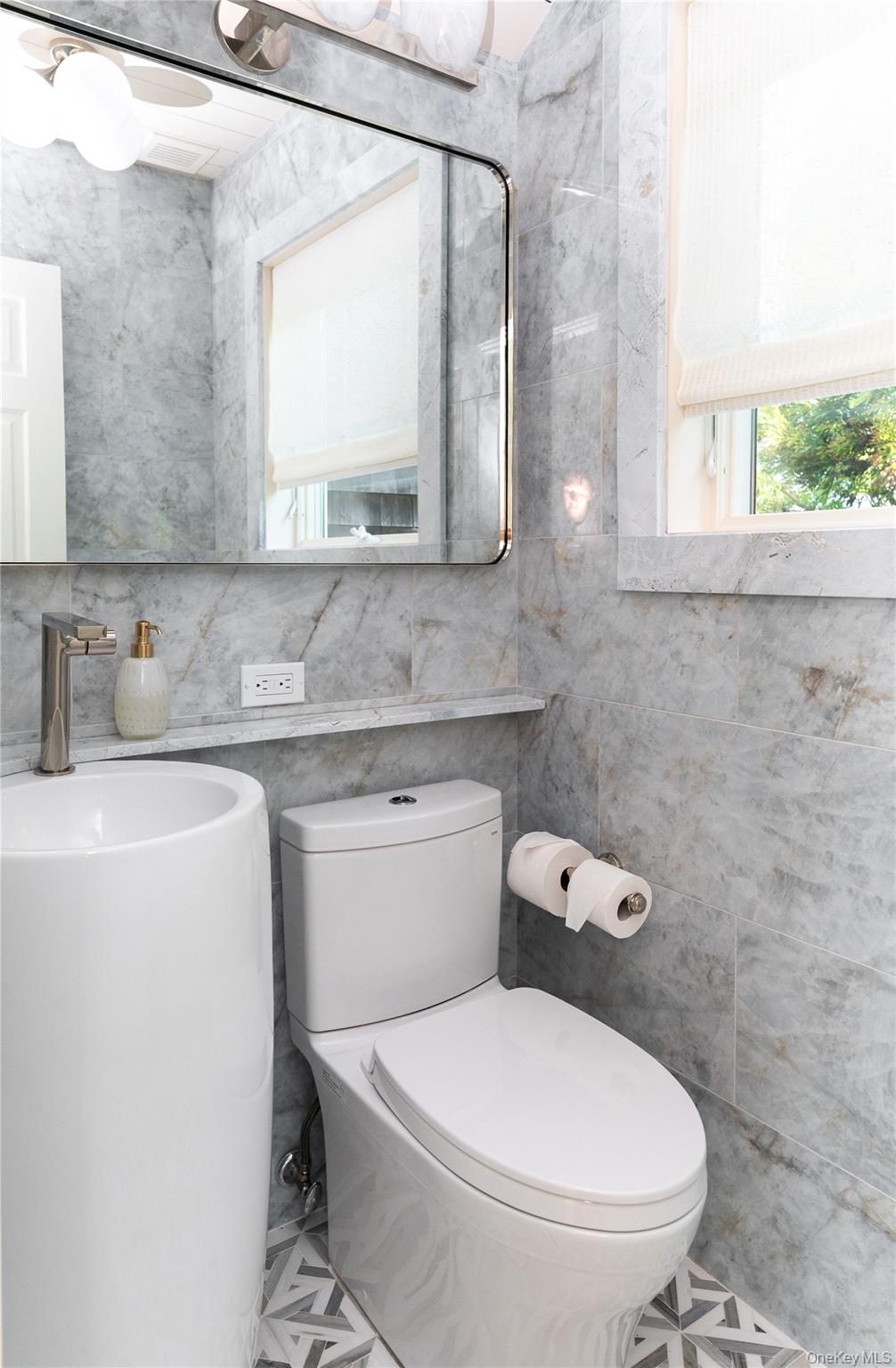 1005 Surf View Ocean Beach, NY 11770 - Photo 29 of 43 a bathroom with a toilet sink and mirror