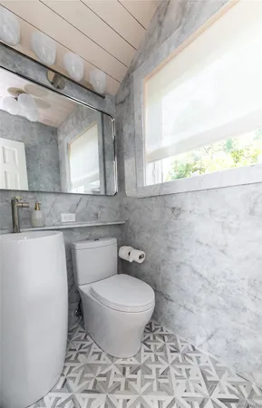 a bathroom with a toilet a sink and a window
