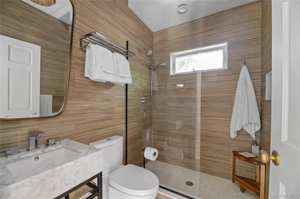 a bathroom with a sink a toilet and shower