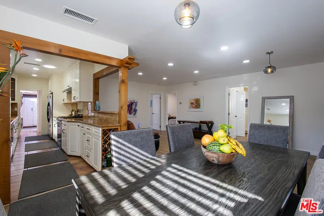 a kitchen with a dining table wooden cabinets and white appliances