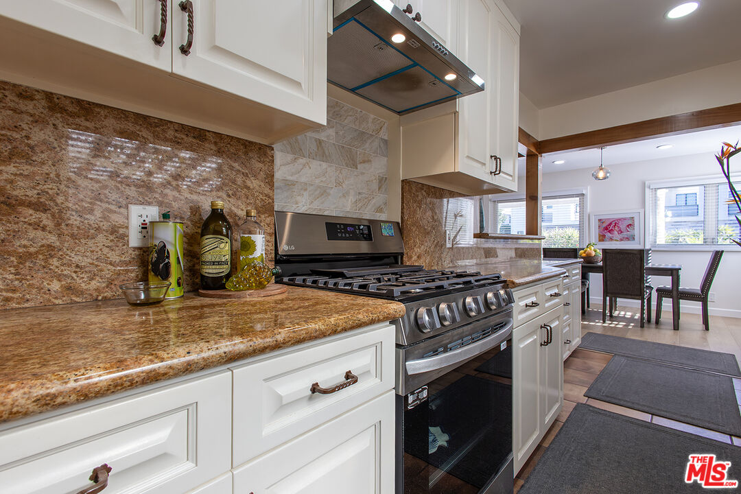 5123 Noble Avenue Sherman Oaks, CA 91403 - Photo 7 of 22 a kitchen with stainless steel appliances granite countertop a stove a sink and a microwave