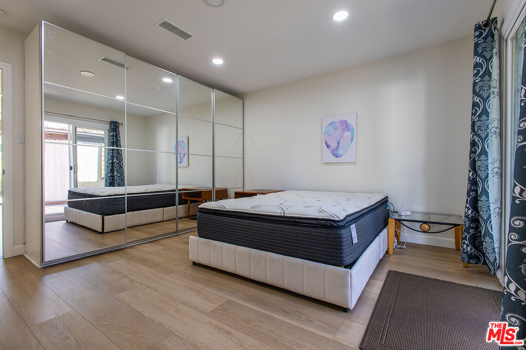 5123 Noble Avenue Sherman Oaks, CA 91403 - Photo 10 of 22 a spacious bedroom with a bed and a large window