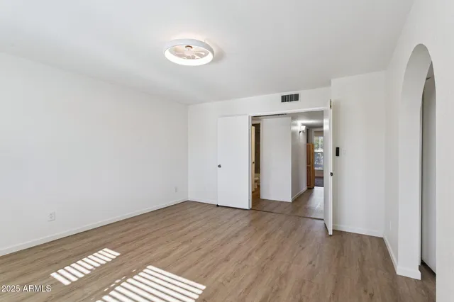 a view of a big room with wooden floor and windows