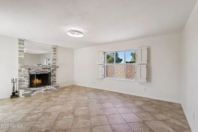 an empty room with fireplace and windows