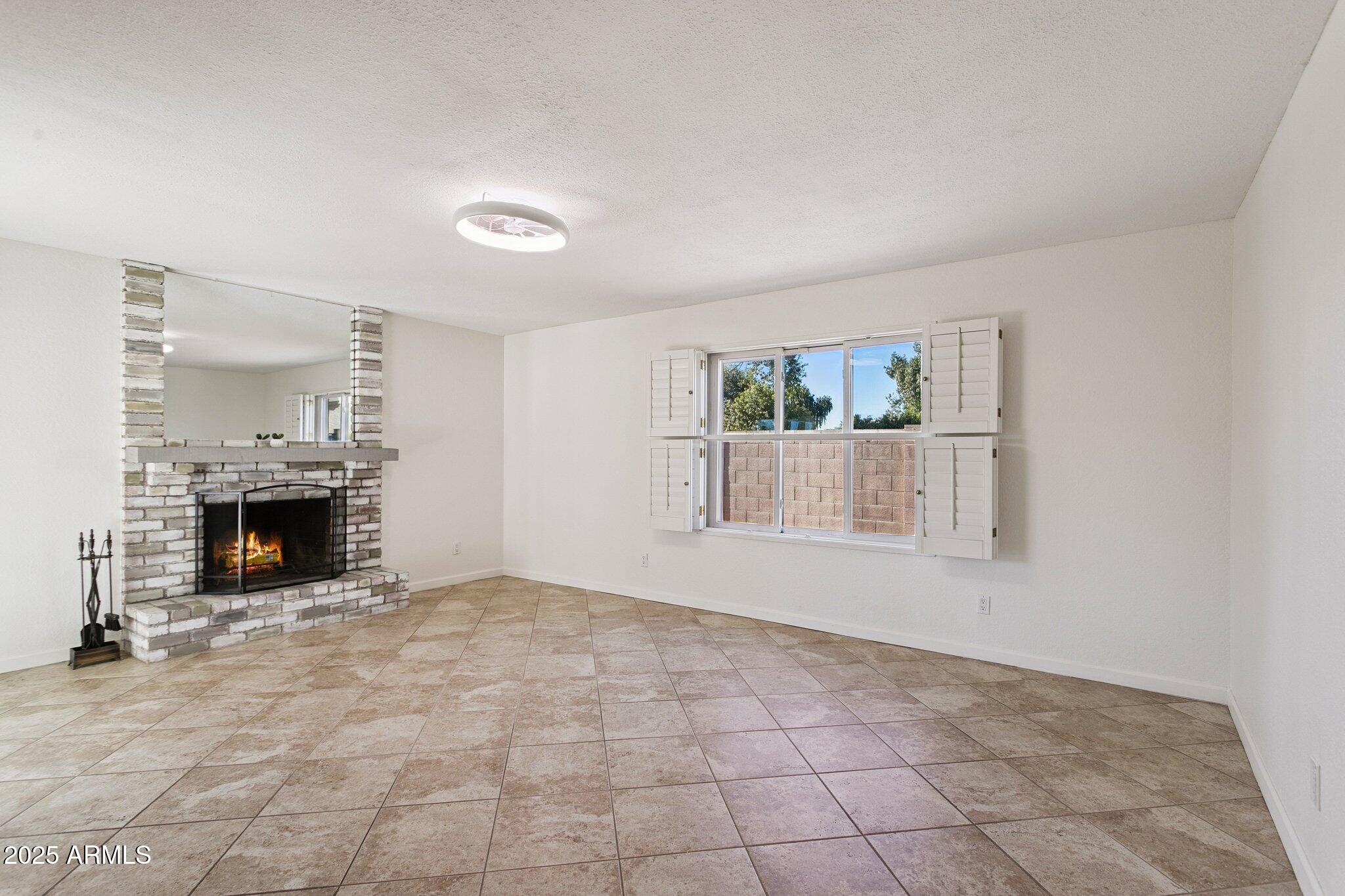4915 East Everett Drive Scottsdale, AZ 85254 - Photo 2 of 39 an empty room with fireplace and windows