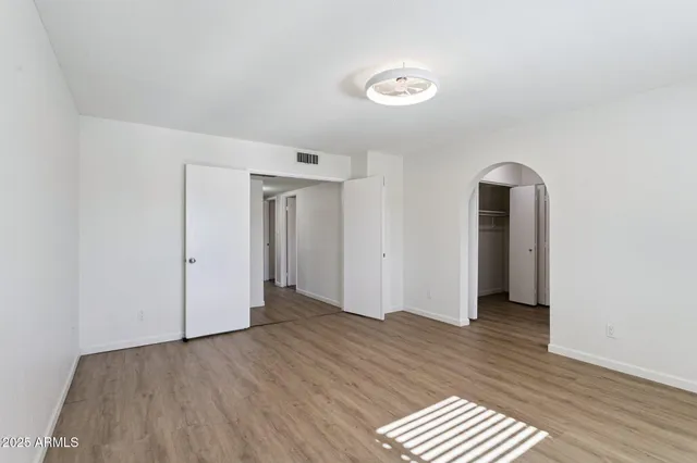 a view of a room with wooden floor and white doors
