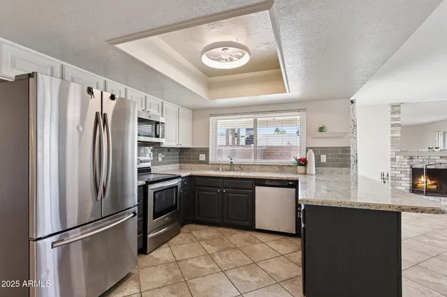 a kitchen with stainless steel appliances granite countertop a refrigerator a stove a sink and a refrigerator