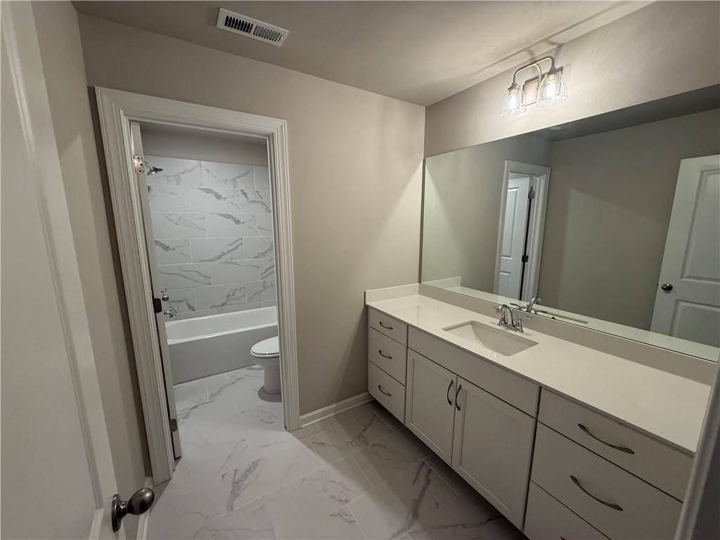 329 Lakeside Drive Canton, GA 30114 - Photo 18 of 34 a bathroom with a double vanity sink toilet mirror and bathtub