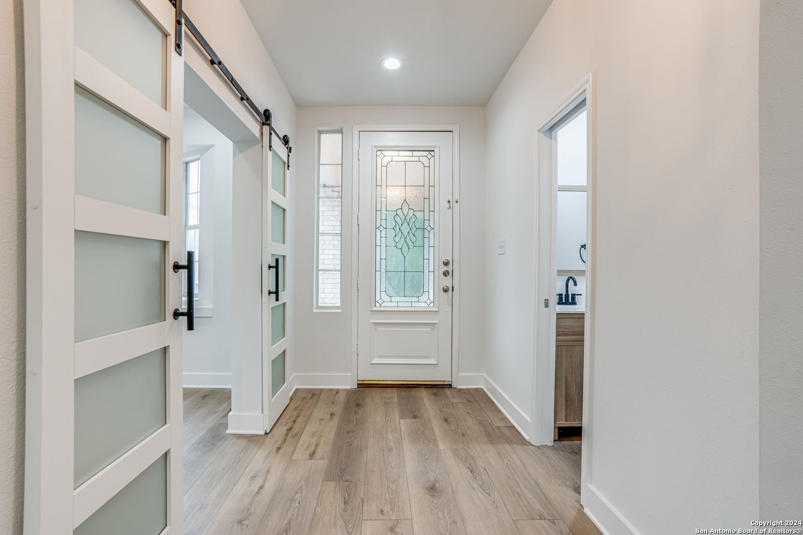 a view of a hallway with wooden floor and closet area