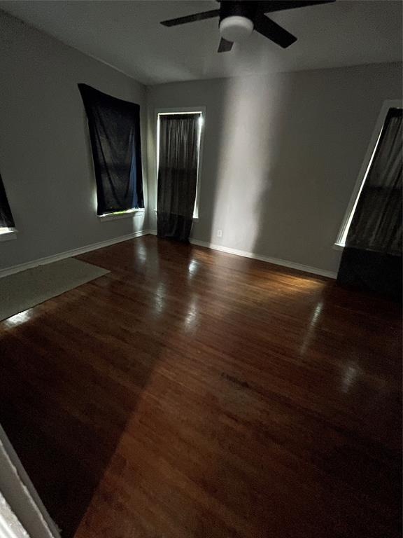 2517 Amelia Street Dallas, TX 75235 - Photo 3 of 7 an empty room with wooden floor and windows
