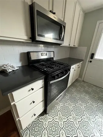 a kitchen with stainless steel appliances a stove and a microwave