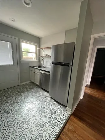 a kitchen with granite countertop a refrigerator and a sink