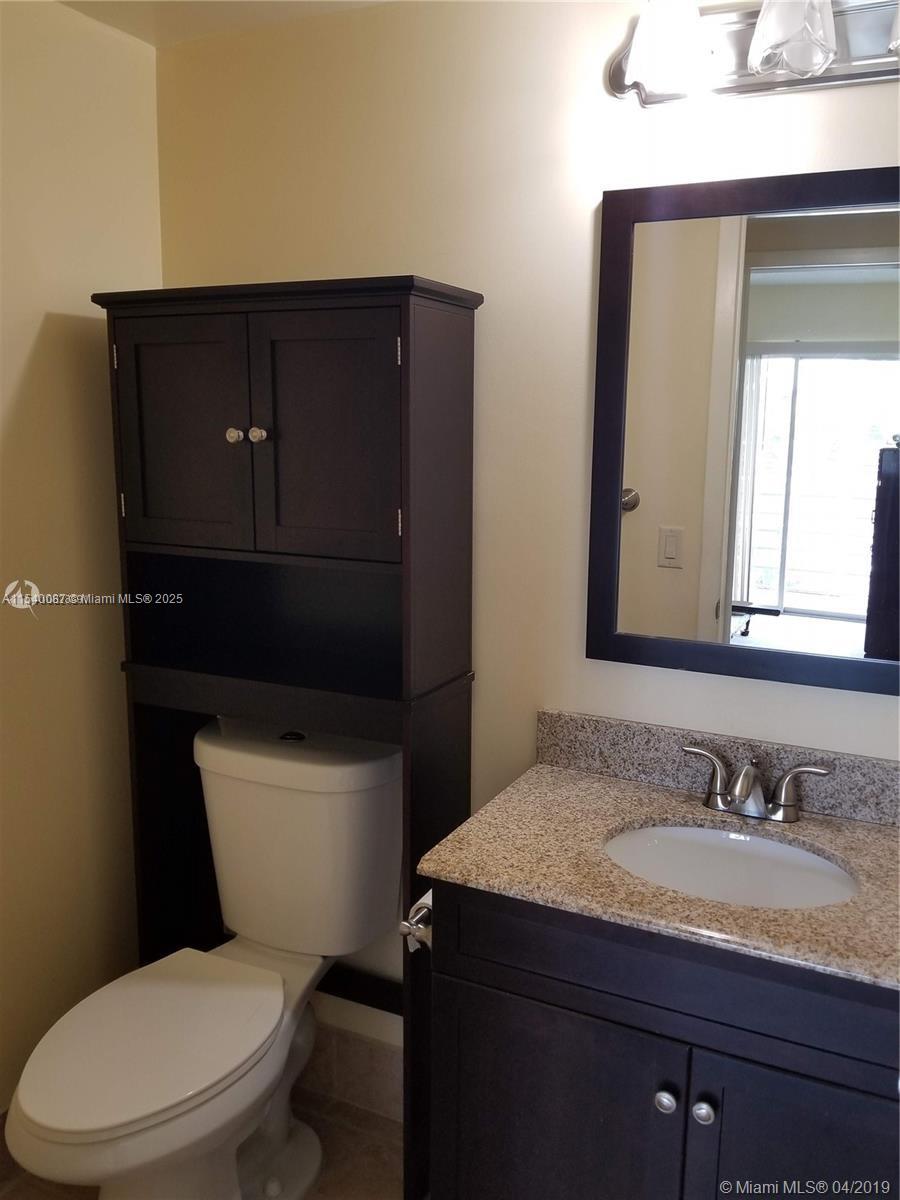 366 Fanshaw I, Unit 366 Boca Raton, FL 33434 - Photo 6 of 25 a bathroom with a granite countertop toilet sink and mirror