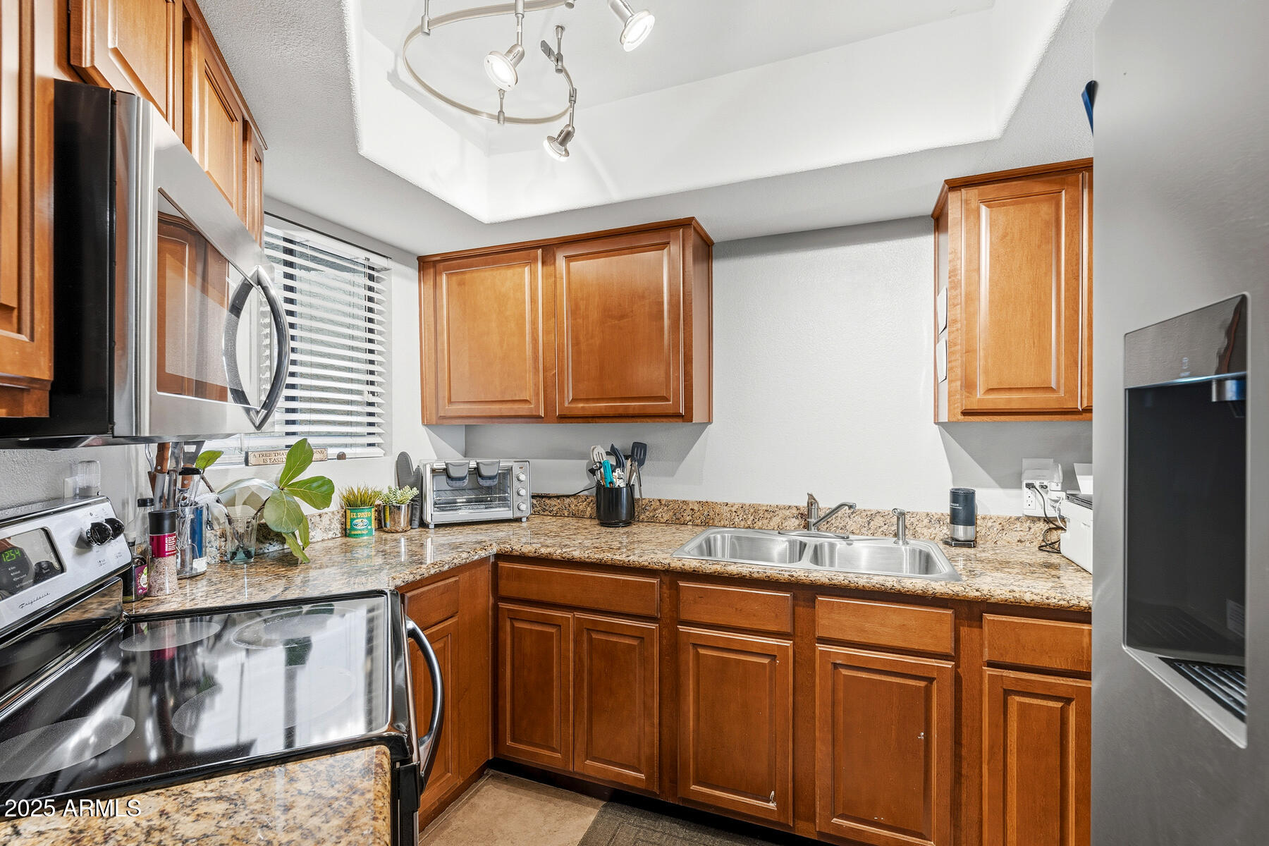 835 North Granite Reef Road, Unit 12 Scottsdale, AZ 85257 - Photo 8 of 23 a kitchen with stainless steel appliances granite countertop a sink stove and cabinets