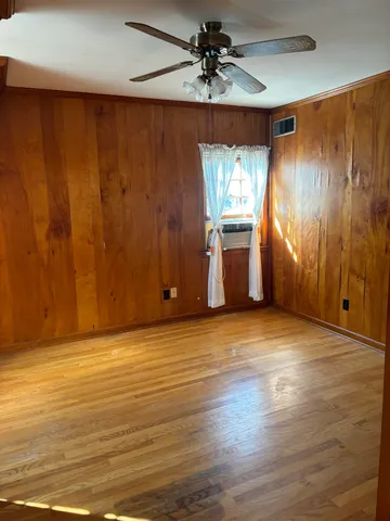 a view of a house with a yard and a large tree