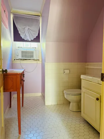 a bathroom with a sink and mirror with toilet