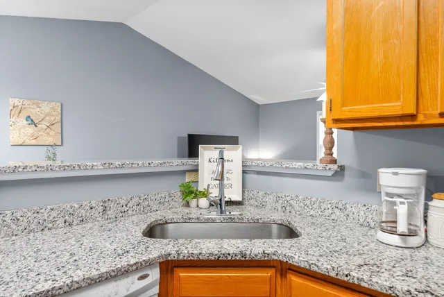 a kitchen with granite countertop a sink and a wooden floor