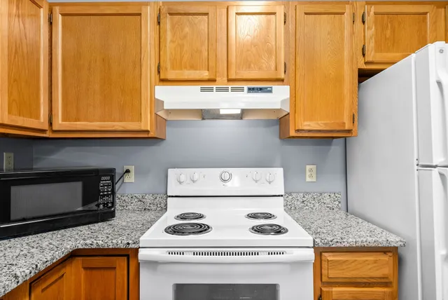 a kitchen with granite countertop cabinets stove and sink