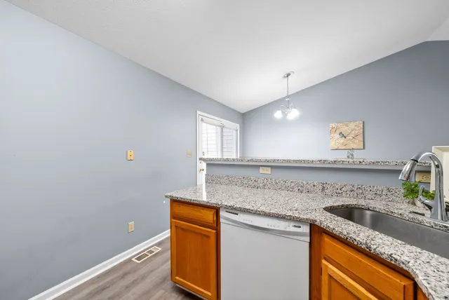 a kitchen with granite countertop cabinets stainless steel appliances and a sink