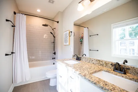 a bathroom with a granite countertop tub sink toilet and shower