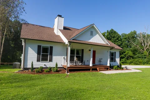 a view of a house with backyard and porch